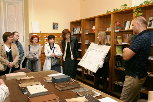 Bibliotekos kultūrinės veiklos vadybininkė Sonata Šulcė lankytojams rodo fonduose išsaugotą retą pergamentą. Valentinos Kulikauskienės nuotr.. 