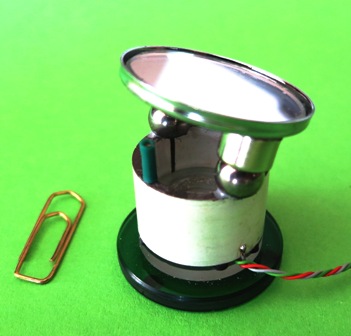 Didelės kampinės skyros lazerio spindulio deflektoriaus nuotrauka ir schema: 1 – veidrodis,  2 – pastovus cilindro formos magnetas, 3 – feromagnetinė sfera, 4 – pjezoelektrinis cilindras su  sekcionuotais elektrodai